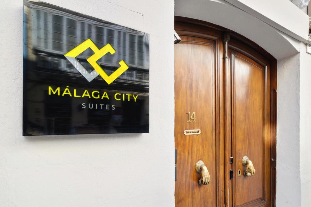 马拉加Malaga City Suites的木门旁建筑物上的标志