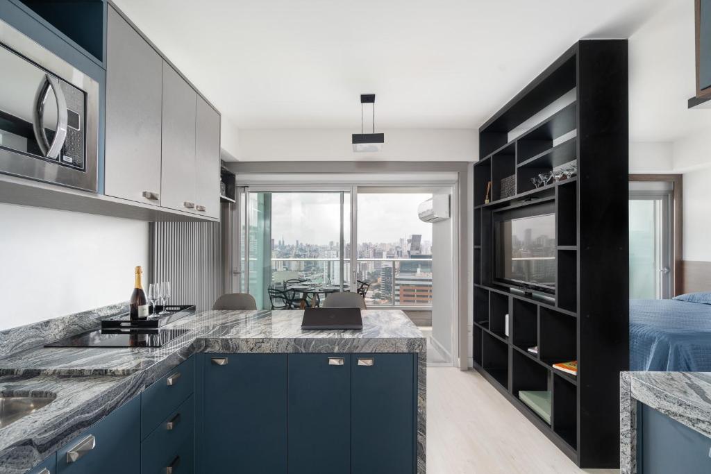 圣保罗River One 2303 - Luxury Studio的一间设有蓝色橱柜和大窗户的厨房
