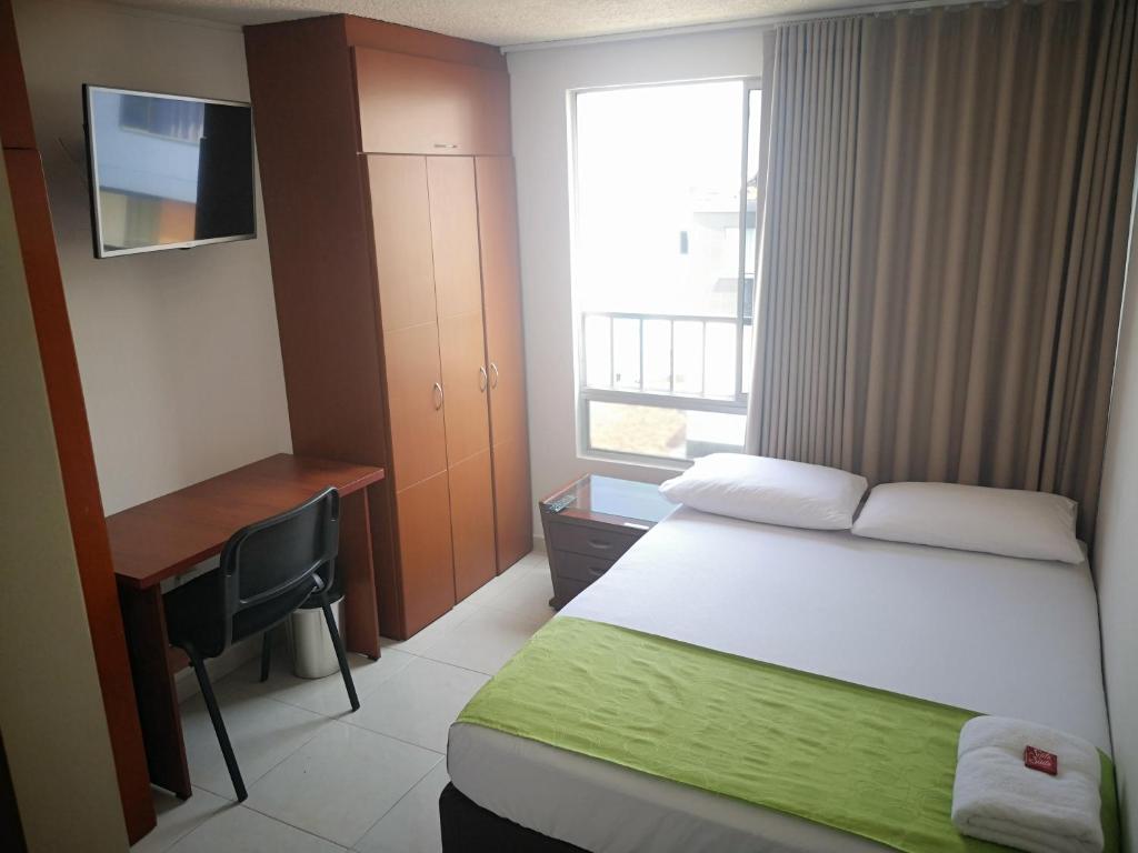 布卡拉曼加Habitar de Asis的一间卧室配有一张床、一张书桌和一个窗户。