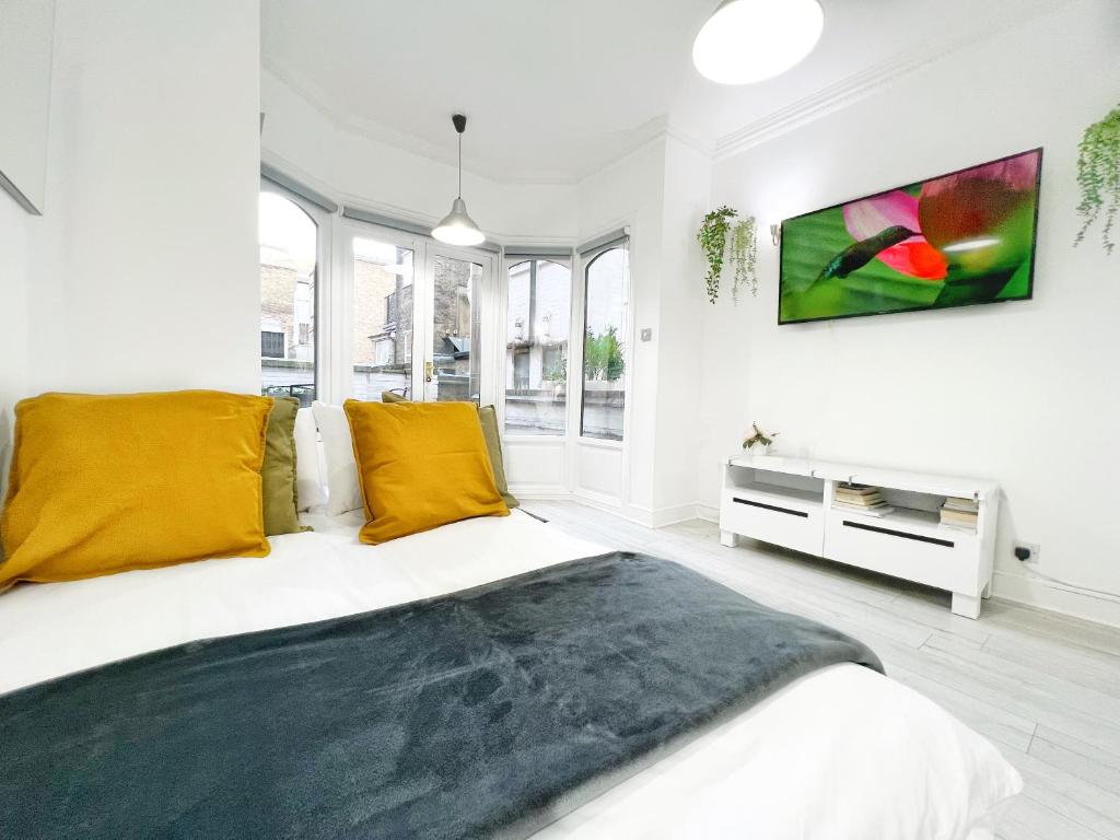 伦敦LUXURIOUS Terrace 2 Bedrooms in Relaxing Covent Garden Apartment的白色卧室配有一张带黄色枕头的大床