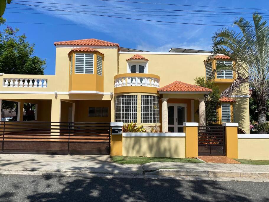 伊莎贝拉Villa Del Carmen Family Vacation Home的前面有栅栏的黄色房子