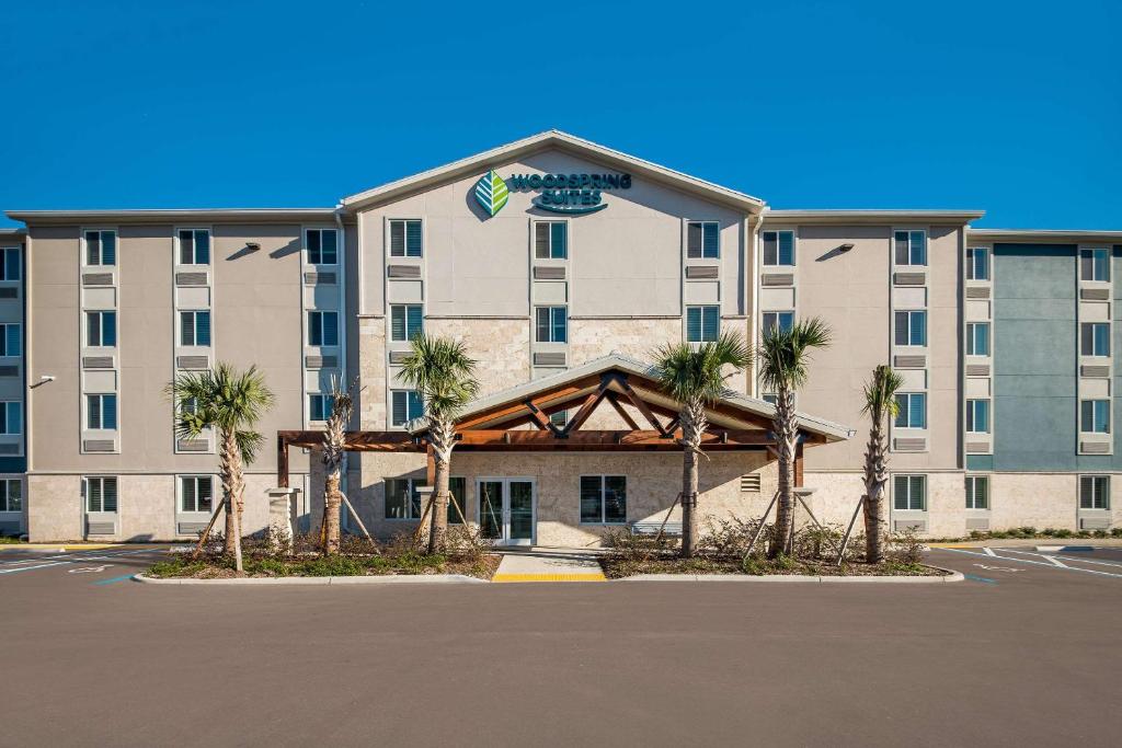 卫斯理堂WoodSpring Suites Wesley Chapel-Tampa的停车场内棕榈树的酒店