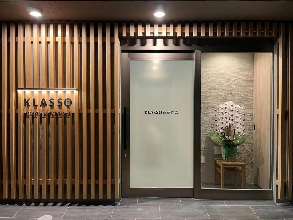 东京KLASSO Tokyo Sumiyoshi Apartments的花瓶装玻璃门的建筑