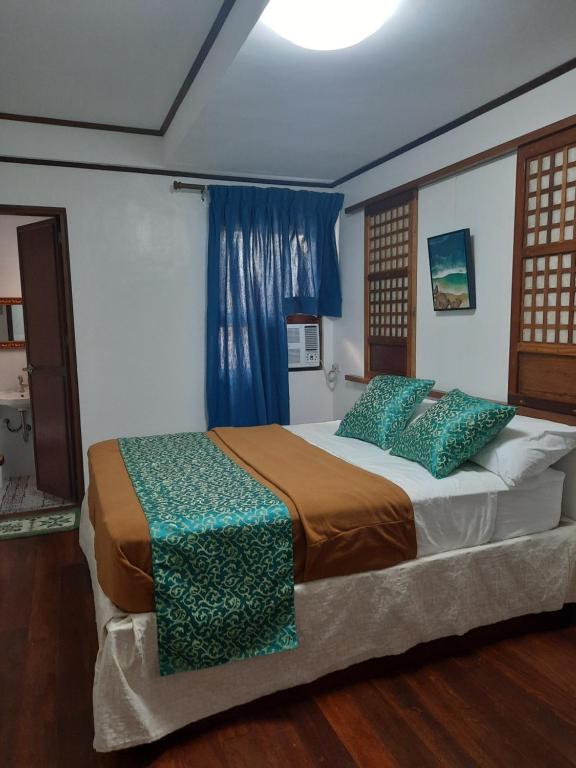 MalabañasBALÉ的一间卧室配有一张带蓝色窗帘的大床