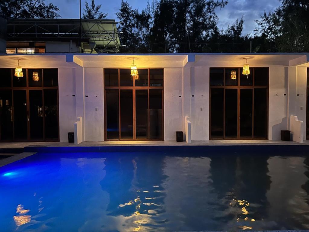 ZambalesLaZerena Lodge的夜间在房子前面的游泳池