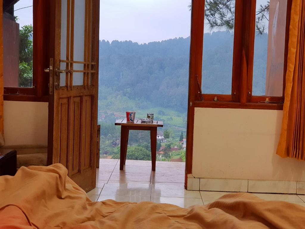 希维德Argapuri Jungle Resort Ciwidey的通往带床和桌子的房间的敞开门