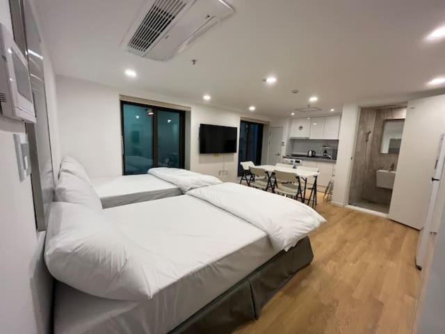 首尔318 Stay - Foreigners Only的一间白色的大卧室,配有两张床和厨房