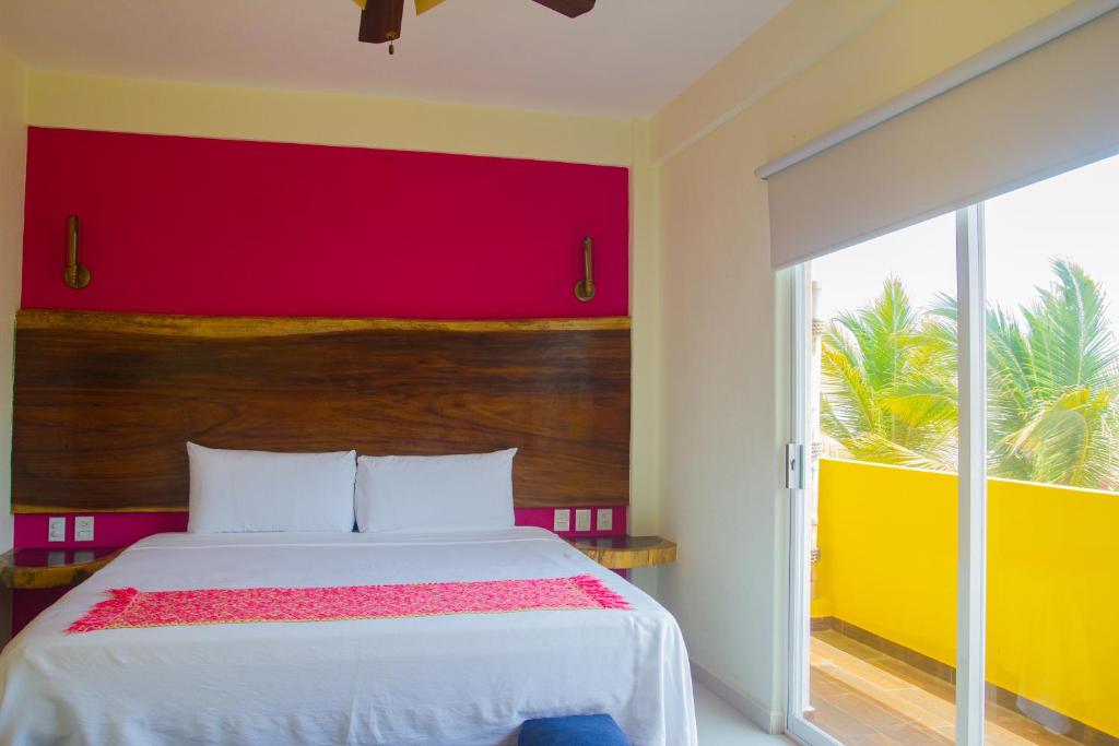 锡瓦塔塔内霍Hotel Happy Beach的一间卧室设有一张红色和黄色墙壁的床