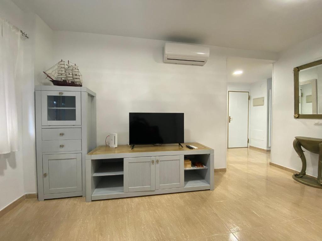 多列毛利诺斯TORREMOLINOS CENTRO - Beautiful , newly renovated 2 bedroom apartment的娱乐中心设有带电视的客厅