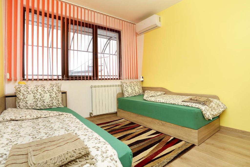 鲁塞Детелина的一间卧室设有两张床和窗户。
