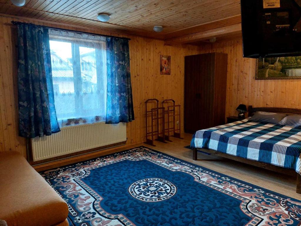 塔塔里夫Сімейний котедж У Діани的一间卧室配有一张床和蓝色地毯