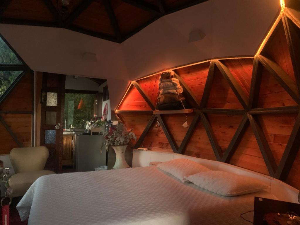 里奥内格罗PrivaDome的一间卧室配有一张木墙床