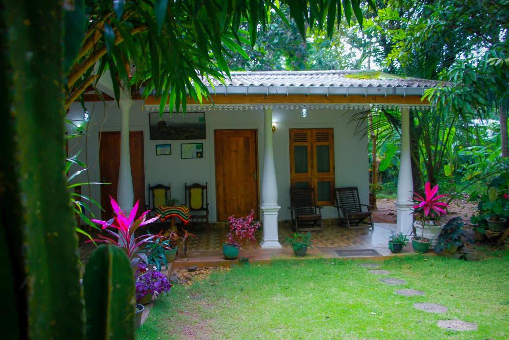 锡吉里亚Travelodge Sigiriya的一座小房子,有门廊和一些植物