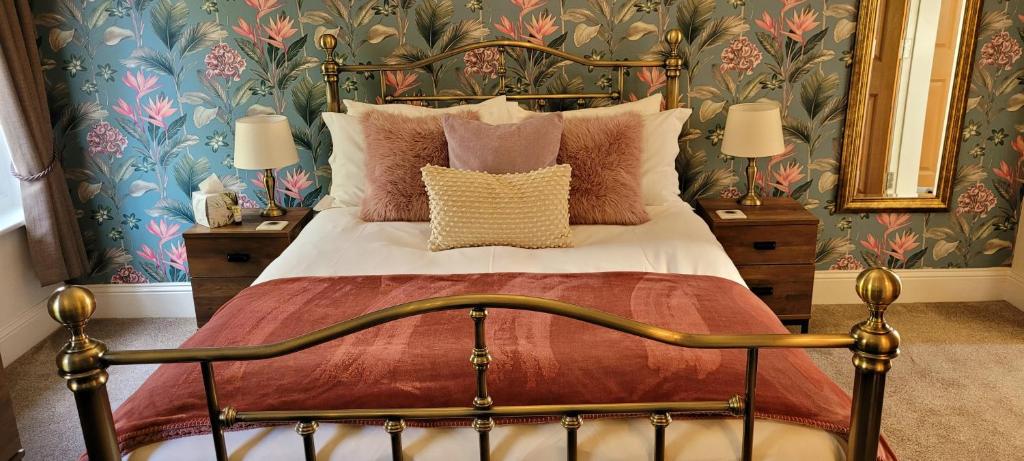 惠特比佛罗伦萨宾馆的一间卧室配有带枕头的床铺和花卉壁纸