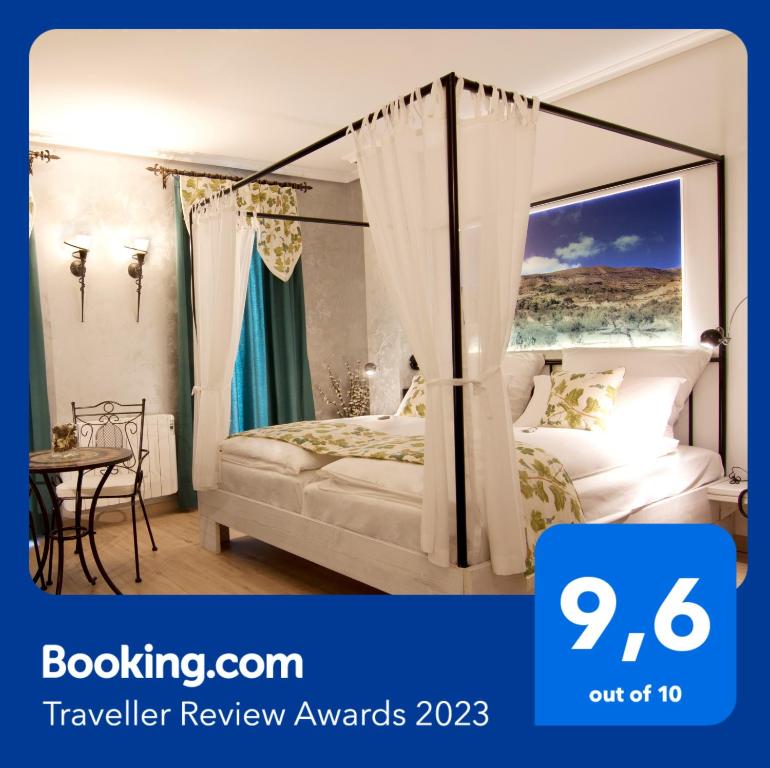 布索特塞拉利昂德阿利坎特精品酒店的一间卧室配有一张天蓬床和一张桌子