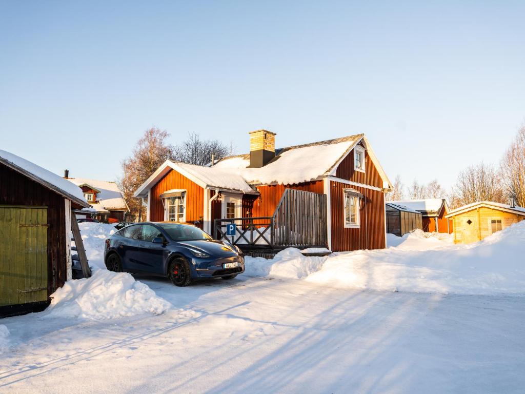 吕勒奥Luleå Village Cabin的停在房子前面的雪地里的汽车