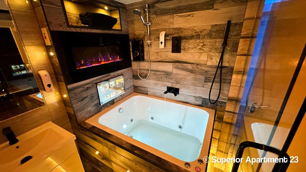 布雷得佛Serenity Apartments Bradford的一间带浴缸和淋浴的浴室以及一台电视。