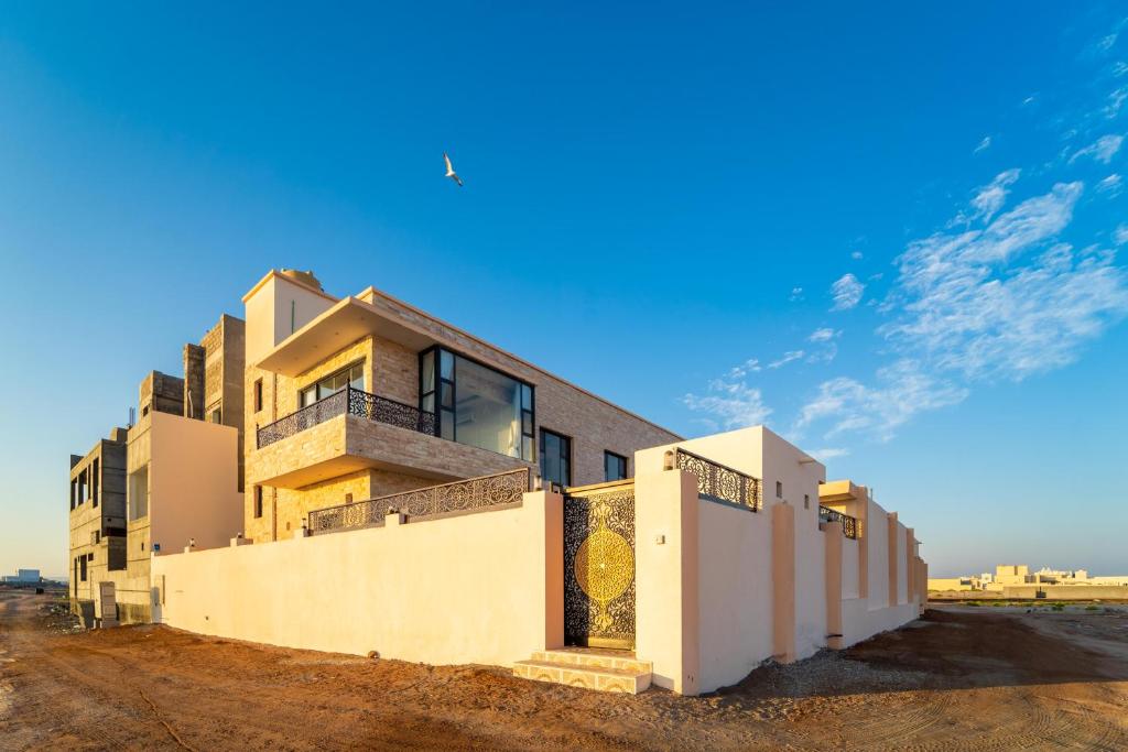 阿尔哈德COMFORT CHALET & APARTMENTS的沙漠中的一座蓝天建筑