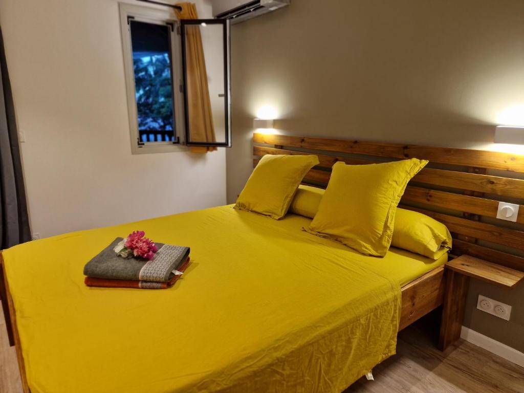 MamoudzouAppartement les petits Baobabs的一张黄色的床,配有木制床头板和黄色枕头