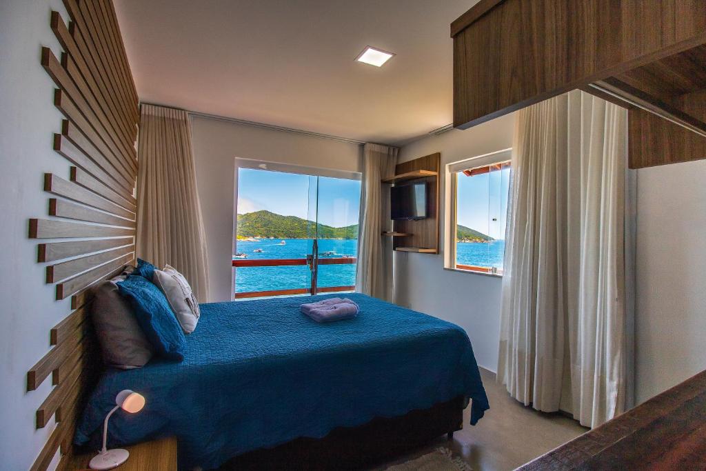 阿拉亚尔-杜卡布Villa Orion的一间享有海景的卧室,配有一张蓝色的床