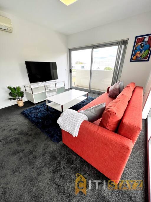 贝尔康嫩Bold in Bruce - 1bd 1bth 1csp的客厅配有红色沙发和电视