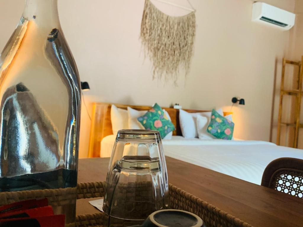 龙目岛库塔Anchor Bed & Bread的一张桌子上的玻璃花瓶和床