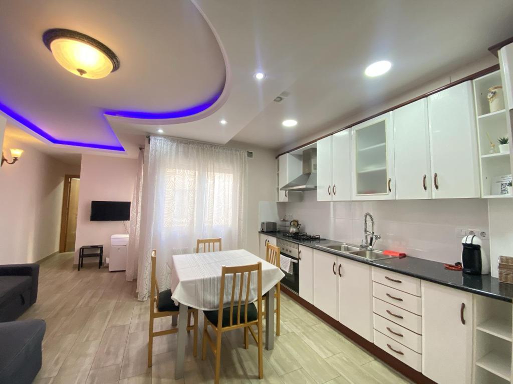 萨瓦德尔Entire New Apartment 20' from Barcelona的一间带桌子的厨房和一间餐厅