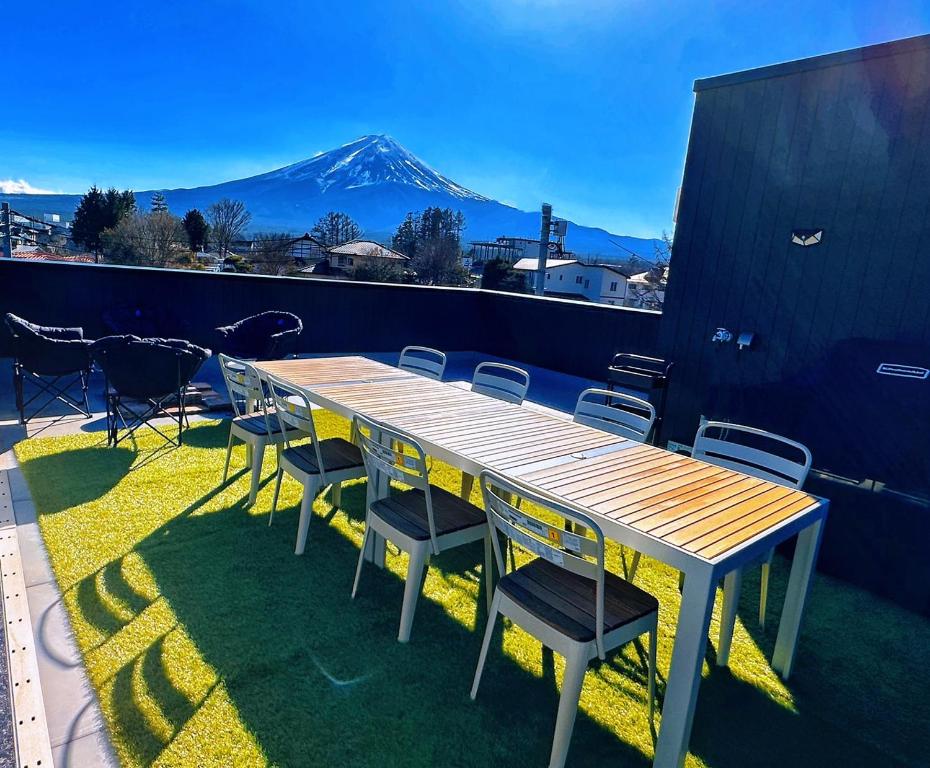 富士河口湖ヴィラ山間堂Panorama Villa BBQ Bonfire Fuji view Annovillas Sankando的山景阳台上的木桌和椅子