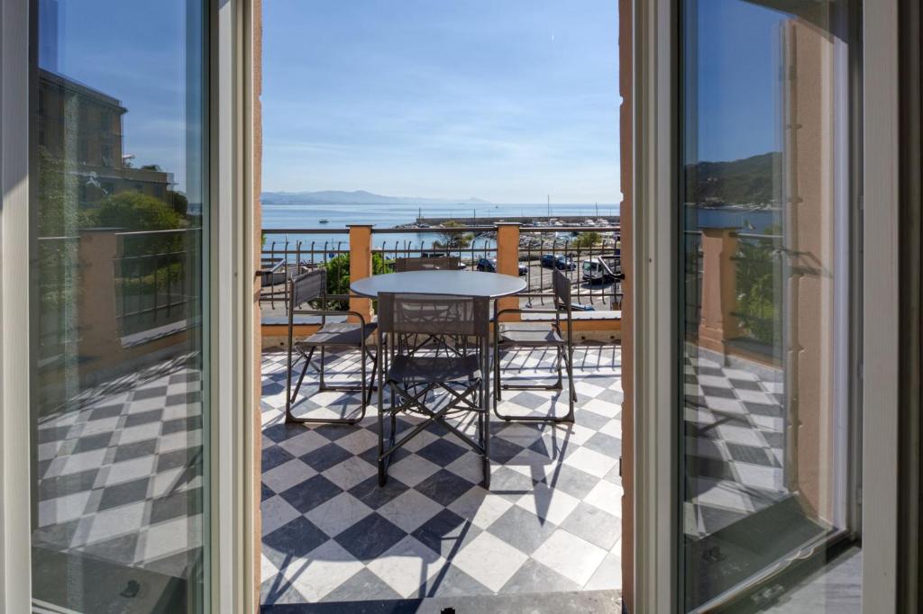 阿伦扎诺Residence Via Di Francia的阳台配有桌椅,享有海景。