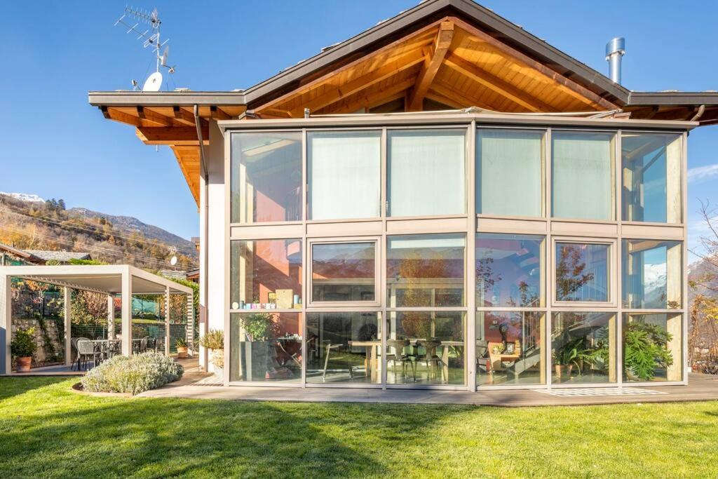 奥斯塔仙果住宿加早餐旅馆 的草坪上设有大型玻璃窗的房子