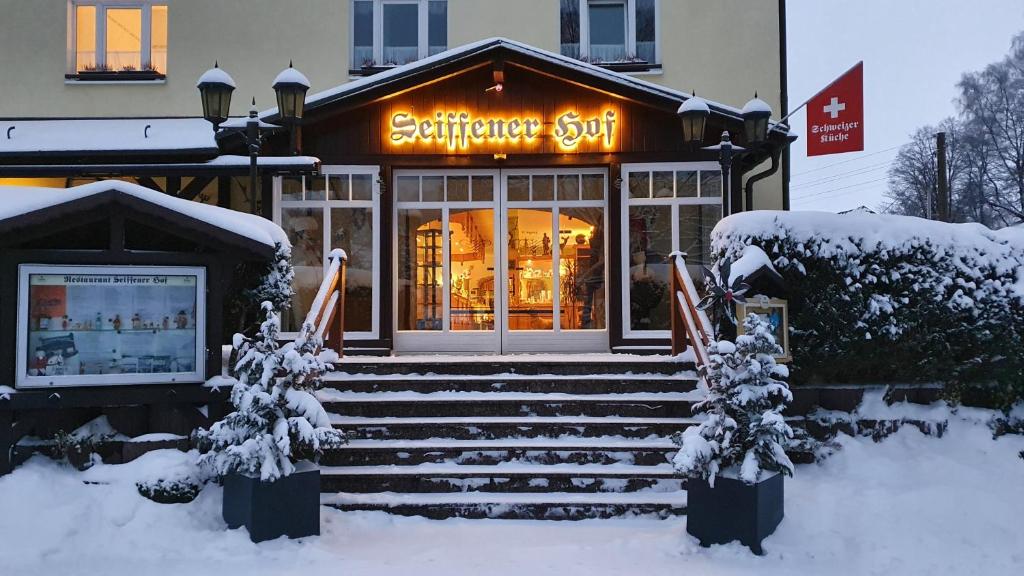 塞芬Hotel Seiffener Hof***的雪上标有标志的商店