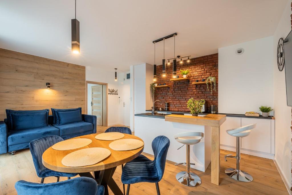 科沃布热格Horyzont Apartamenty -Bałtycka2 - SAUNA & FITNESS - ŚNIADANIA的客厅配有桌子和蓝色沙发