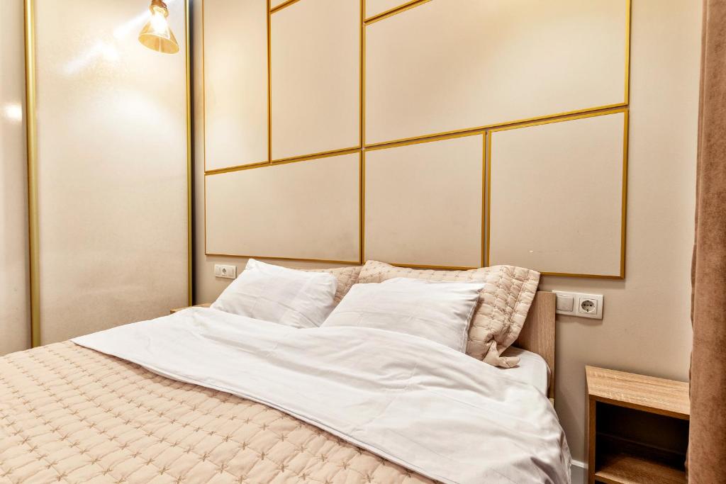 塔尔迪科尔Апартаменты в районе Экспо的一张带白色床单和枕头的床