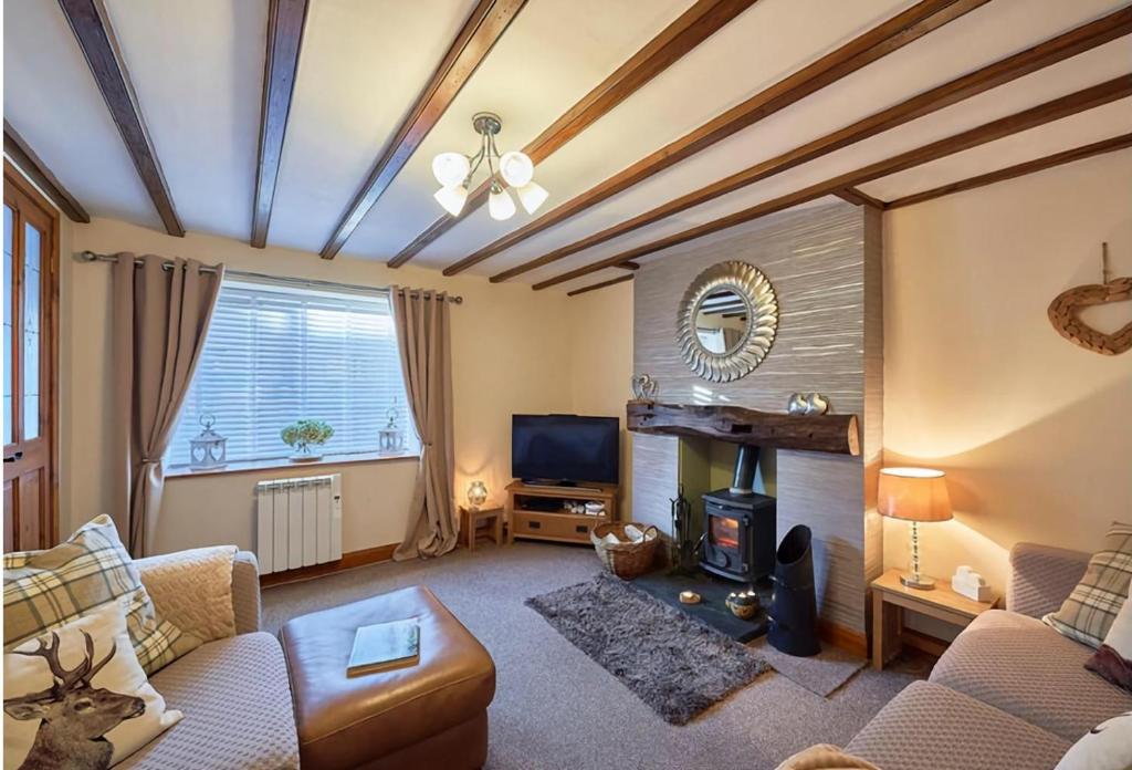 布拉夫Cosy Cumbrian cottage for your country escape的带沙发和壁炉的客厅