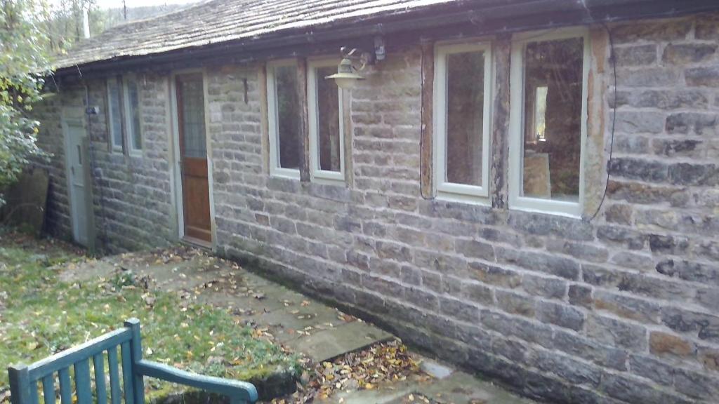 奥尔德姆Millstone cottage的砖房,前面有长凳