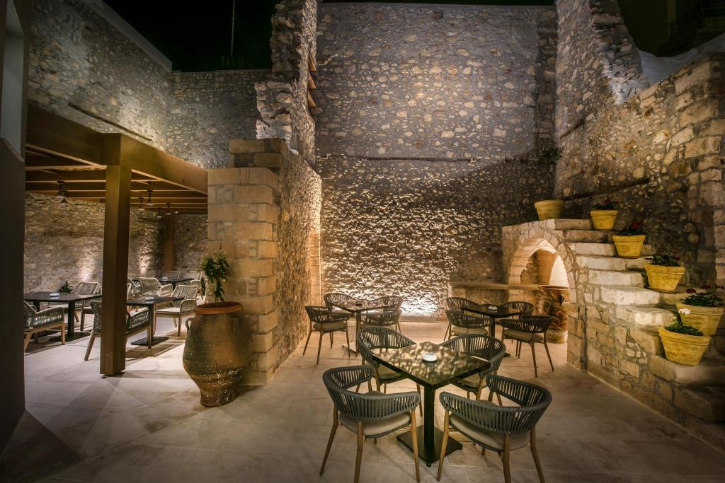 海若克利欧Dimargio Luxury Hotel & Spa的一间带桌椅的餐厅以及砖墙