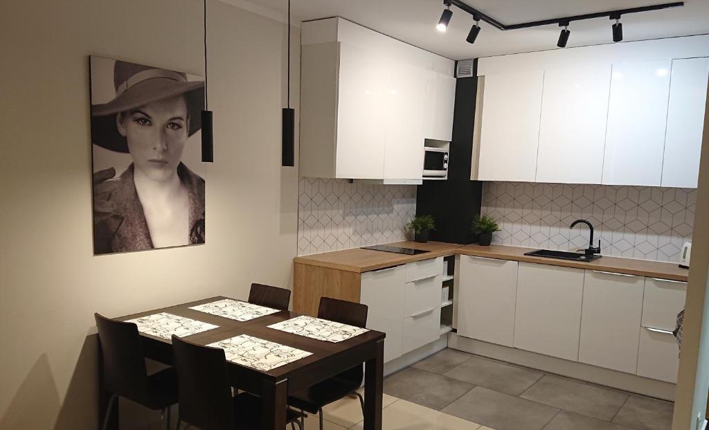 达洛科Apartament Jantar 3B w Darłówku的厨房配有桌子和黑白相间的图片