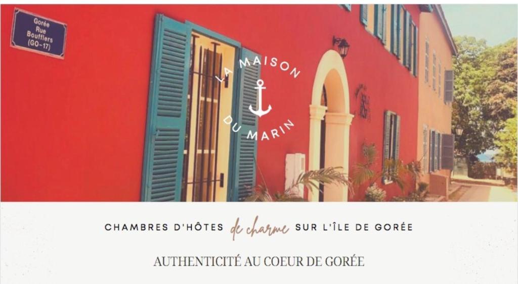 格雷岛La Maison du Marin的一张红色建筑的照片,上面有标志