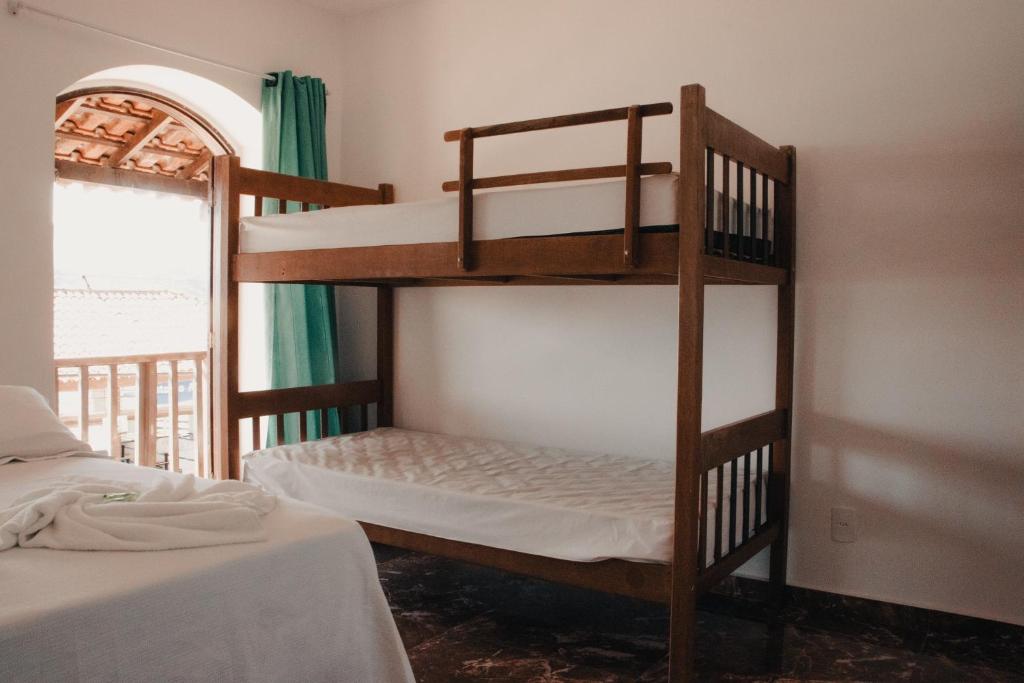 阿布拉奥Beira Mar Hostel & Suítes的一间卧室设有两张双层床和一扇窗户。