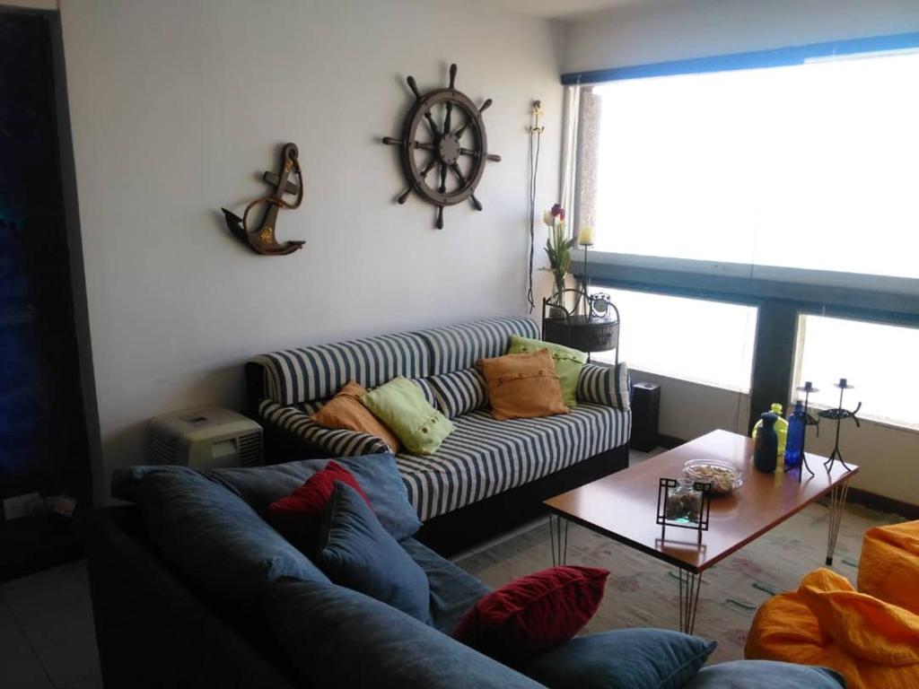 拉瓜伊拉Acogedor apartamento con piscina - Bleu Marine Suites的客厅配有沙发和桌子