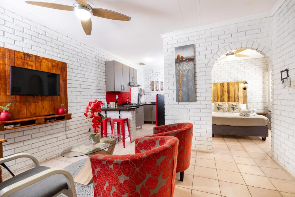 内尔斯普雷特Rozelee Rest 1的客厅配有红色椅子和白色砖墙