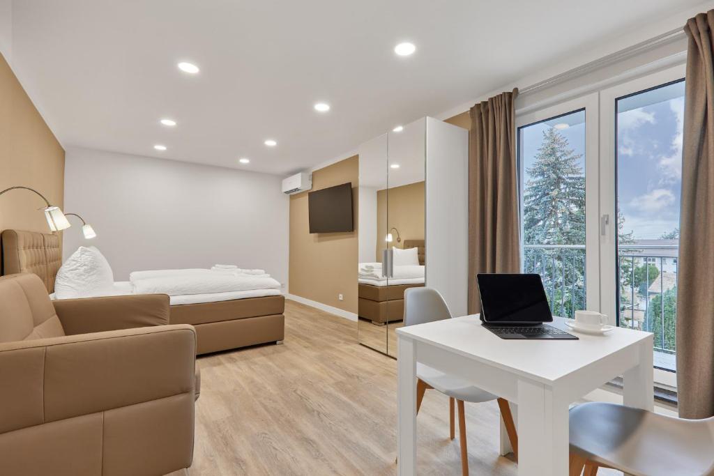海德堡Boardinghotel Premium Heidelberg的客房设有一张床、一张桌子和一台笔记本电脑