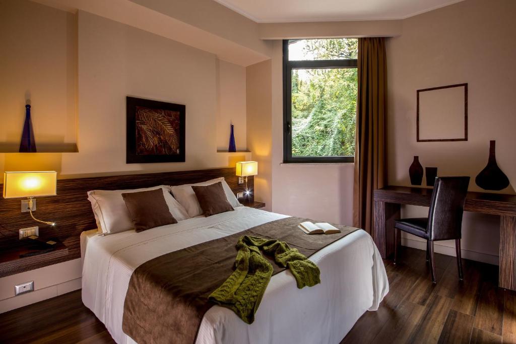 马利亚诺萨比纳萨宾娜公园酒店的一间卧室配有一张床、一张书桌和一个窗户。
