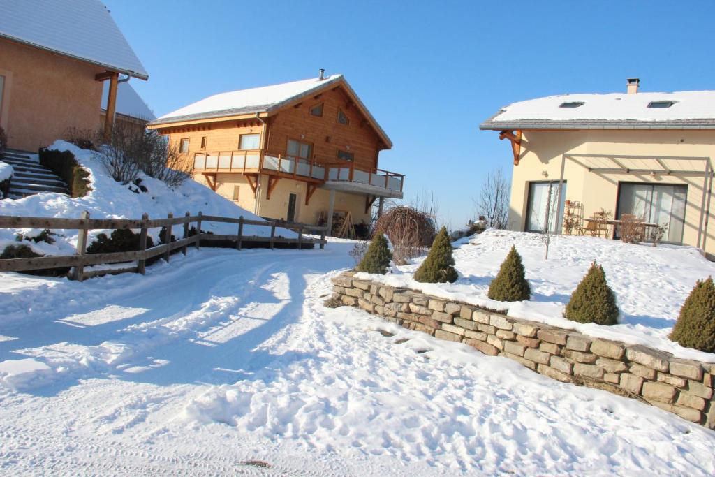 昂塞勒ANCELLE TAILLAS RDC CHALET的一座有房子和建筑物的雪盖庭院