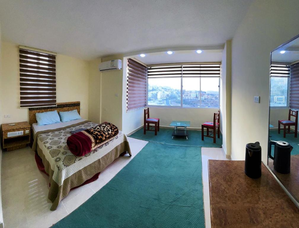 瓦迪穆萨Orient Gate的卧室配有一张床和一张桌子及椅子