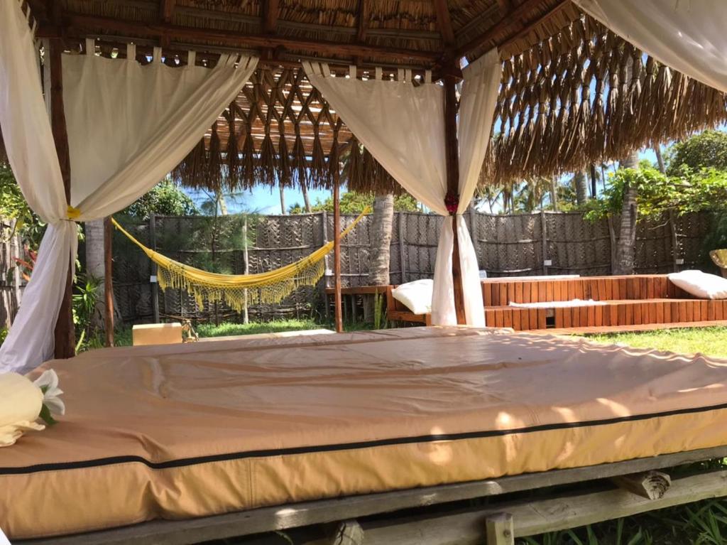 托弗海滩Casa Bali Tofo的凉亭内的一张床位,配有吊床