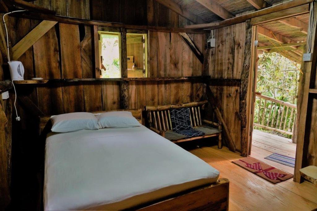 罗索纳蒂热带河谷酒店的木制客房内的一间卧室,配有一张床