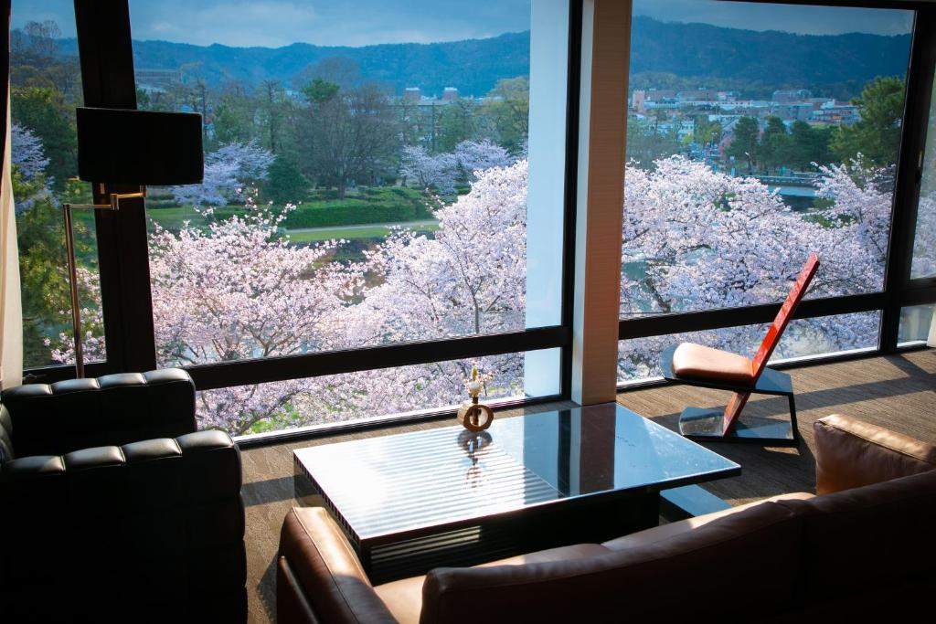 京都Riverte Kyoto Kamogawa的客厅的窗户享有樱树的景致。