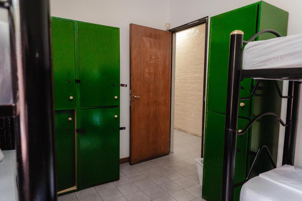 门多萨Clover Hostel的一间绿色储物柜和一张双层床的客房