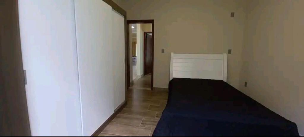 欧鲁普雷图Casa Nova em Ouro Preto e Mariana的一间卧室设有一张床和白色的墙壁